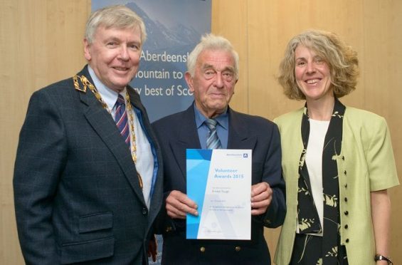 Provost Hamish Vernal and deputy provost Alison Grant present Ernest Tough with his volunteer of the year award last year