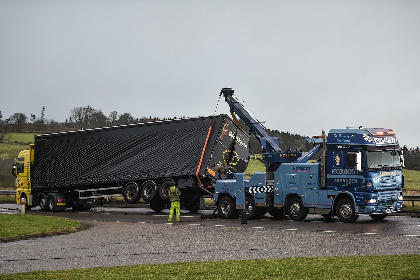 Recovery trucks flip an overturned lorry on the A96 near Huntly,