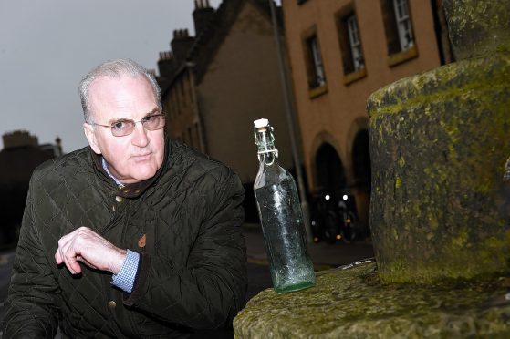 Jim Royan contemplates on an old Elgin bottle