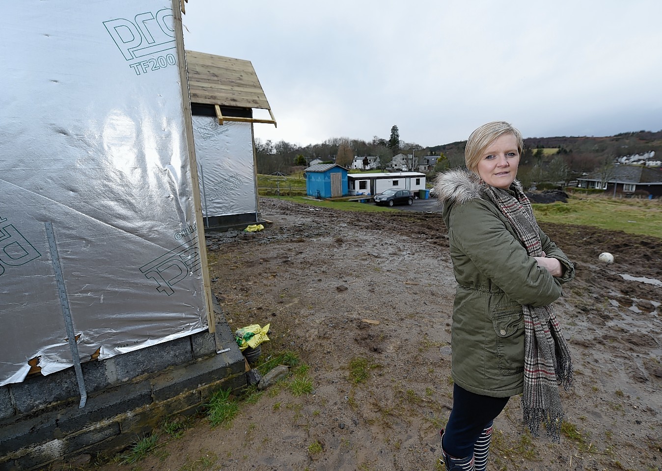 Emily Macdonald of Woodside, West Park, Strathpeffer with their partially built home and the caravan 