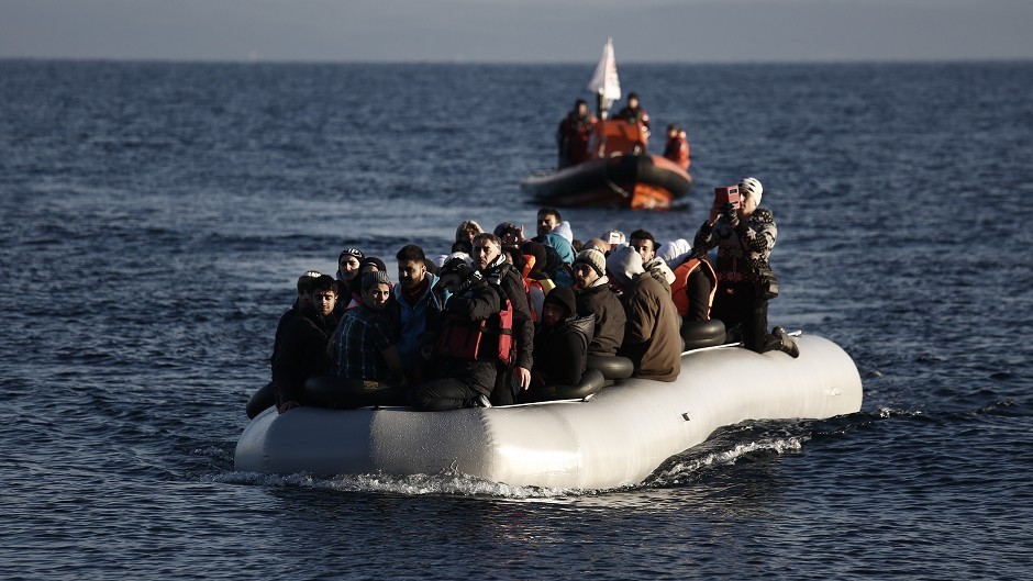 Refugees and migrants arrive on a dinghy from the Turkish coast to the Greek island of Lesbos (AP)