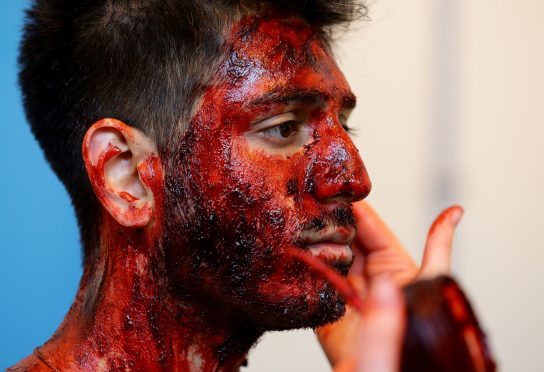 An actor is prepared with makeup for Exercise Unified Response, an emergency services training exercise, at Littlebrook Power Station in Dartford, Kent.