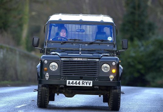Queen Elizabeth II in a Land Rover Defender 110