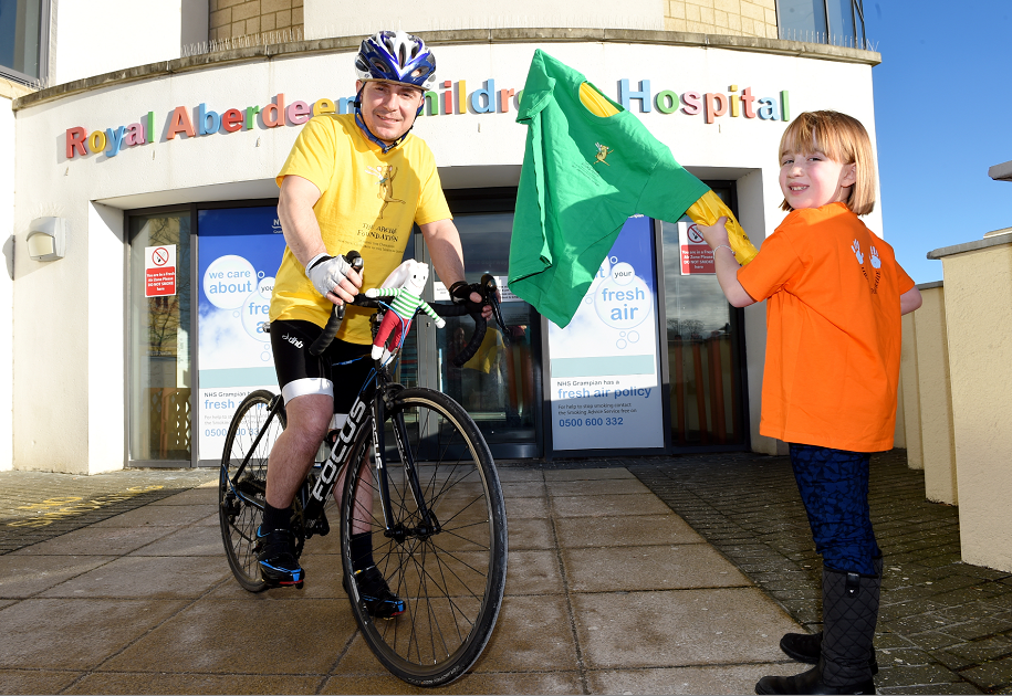 Green for go! Stella Shiner, a patient at Aberdeen Children's Hospital, waves off cyclist Nick Frost who is going to cycle 10,000km round Scotland in aid of the ARCHIE Foundation.