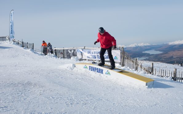 A snowboarder tries the new Rail Park at Nevis Range