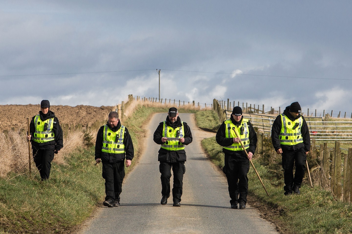 Officers search a single track country road near the home of Brian McKandie