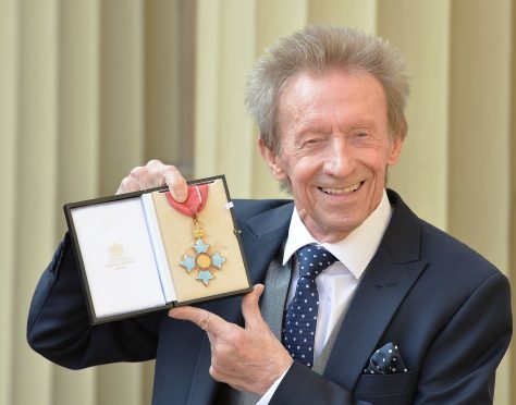 Former Scotland and Manchester United football great Denis Law holds his  Commander of the Order of the British Empire (CBE) medal that was presented to him by the Duke of Cambridge at an Investiture ceremony in Buckingham Palace, London.