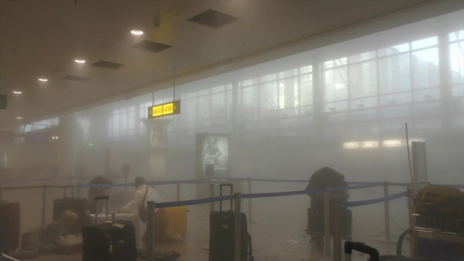 An unidentified traveller gets to his feet in a smoke filled terminal at Brussels Airport (Ralph Usbeck/AP)