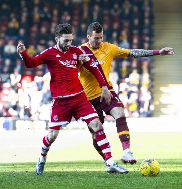 Shinnie attles with Motherwell's Marvin Johnson during Saturday's game at Fir Park