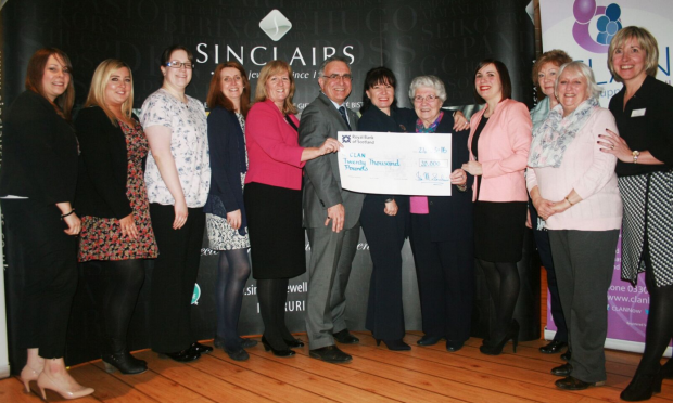 Staff and volunteers from CLAN Cancer Support receive a donation from the Sinclair family