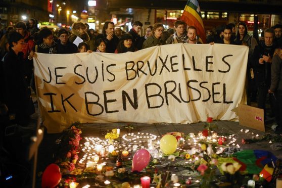 People hold up a banner as a mark of solidarity at the Place de la Bourse