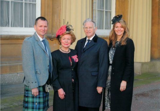 Alison Skene and her family collecting her MBE at Buckingham Palace