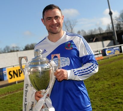 Jamie Watt proudly holds the Highland League trophy