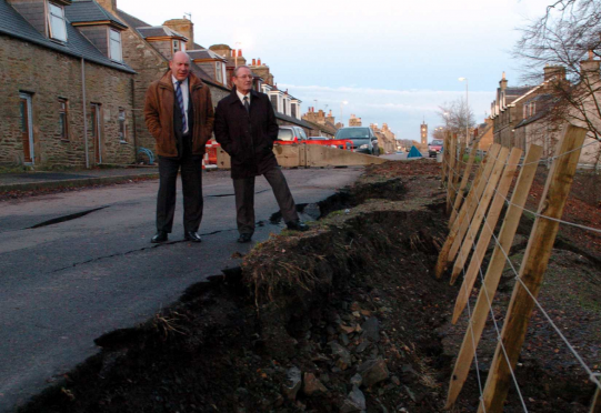 Moray councillors, Stewart Cree, left, and Ron Shepherd, right, by the flood damaged road in Newmill in 2009.