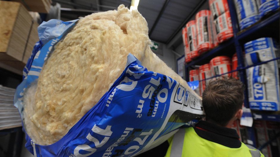 A workers holding a bag of insulation