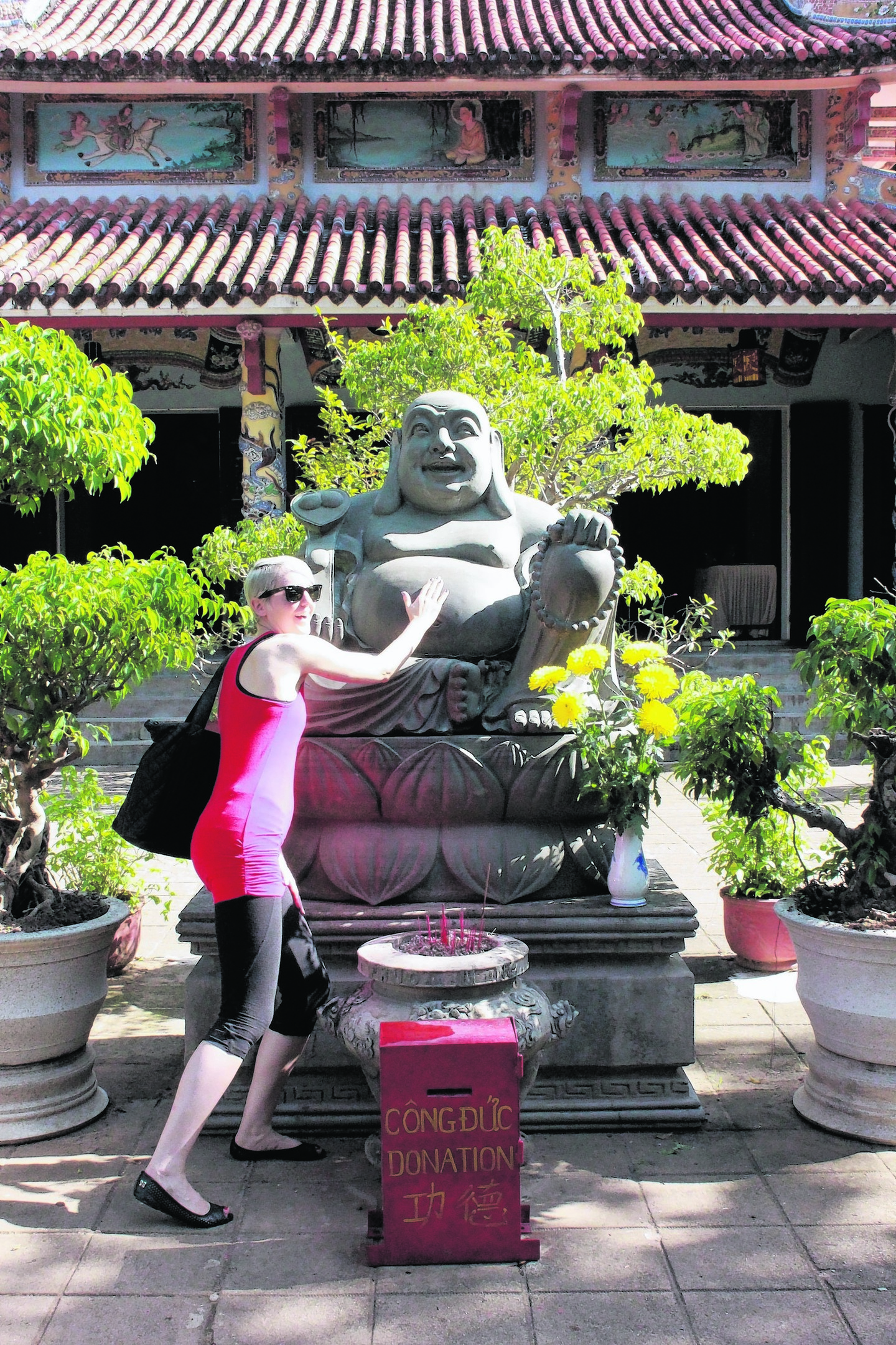 Katie Wright rubbing a buddha's belly for luck. 