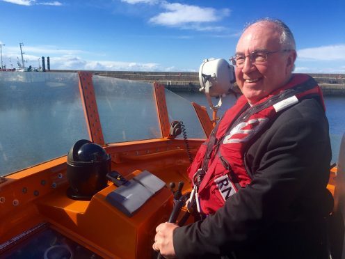 Church of Scotland moderator Rt Rev Dr Angus Morrison at the helm of the lifeboat in Buckie.