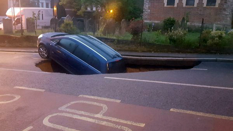 A car which has partially disappeared down a sinkhole in Greenwich, south-east London (Metropolitan Police/Twitter/PA)