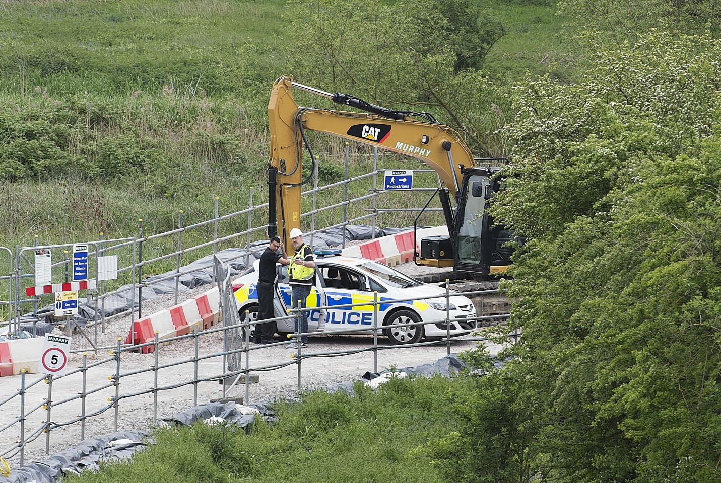 Police search for the remains of a body at Block Fen Quarry where a severed head was discovered on Monday.