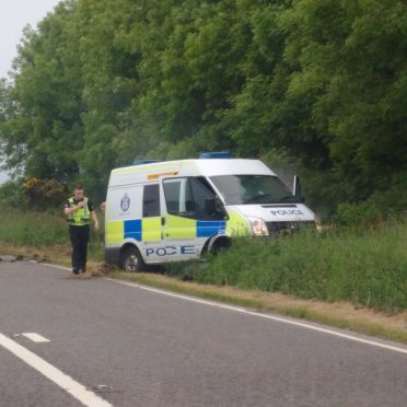 The police van swerved off of the A98 to avoid the boulder