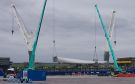Two cranes working in tandem to lift the turbine blades onto special trailers at the Port of Cromarty Firth