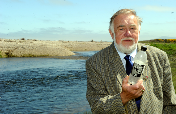 James Mackie, chairman of the James A. Mackie Trust beside the Spey Estuary at Kingston, with a plastic bottle washed ashore. Picture by Gordon Lennox.