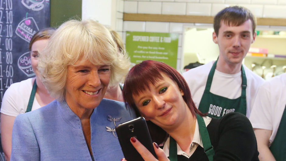 The Duchess of Cornwall, known as the Duchess of Rothesay while in Scotland, has a selfie taken with employee Biffy Mackay, right, during a visit to Social Bite