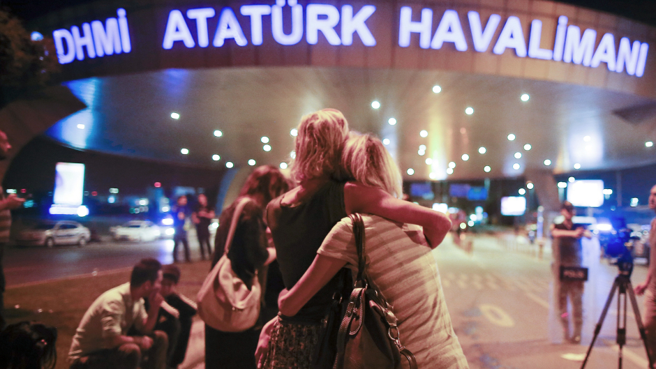 Evacuated passengers embrace at the entrance to Ataturk Airport (AP)