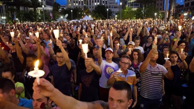 Crowd members hold up candles during a vigil in Orlando for the victims of the mass shooting (AP)
