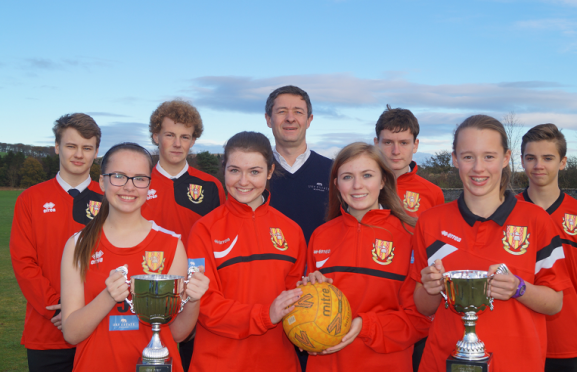 Jonathon Milne, director of the FM Group, with Mackie Academy pupils after the firm sponsored the school's new sports kits