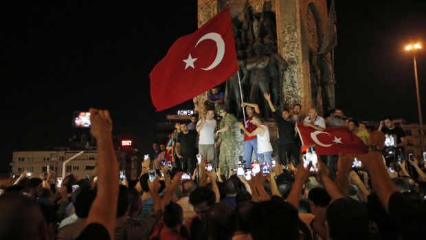 Erdogan supporters wave Turkish flags in Taksim Square (AP)