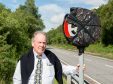 Stewart Maclean of the A82 Partnership with one of the new speed limit signs
