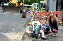achel Martin and children, Daniel 9, and Elizabeth, 6 watch as the council cut down the trees for the repaving the pavements on Murray Terrace, Aberdeen.
Picture: Jim Irvine