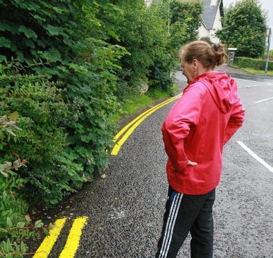 A gap has been left in double yellow lines on a road in Fort William due to overhanging bushes