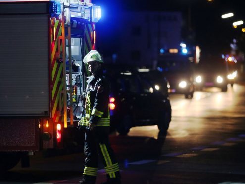 A firefighter stands at a road block in Wuerzburg where man attacked people in a train and injured more than a dozen. (Karl-Josef Hildenbrand/dpa via AP)