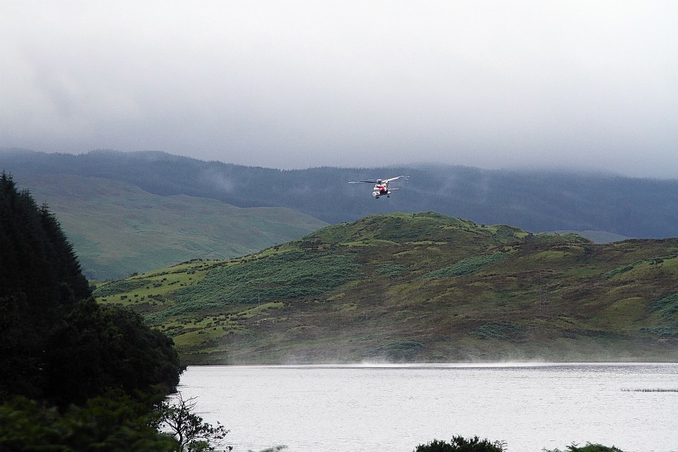 A search and rescue helicopter operating over the loch