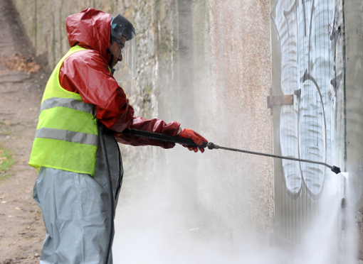 Council staff clean a wall of graffiti