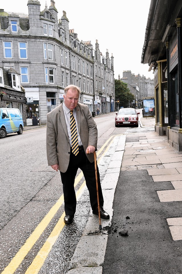 Councillor Bill Cormie who is angry at the council replacing broken and cracked slabs with bitmac on Rosemount Place.