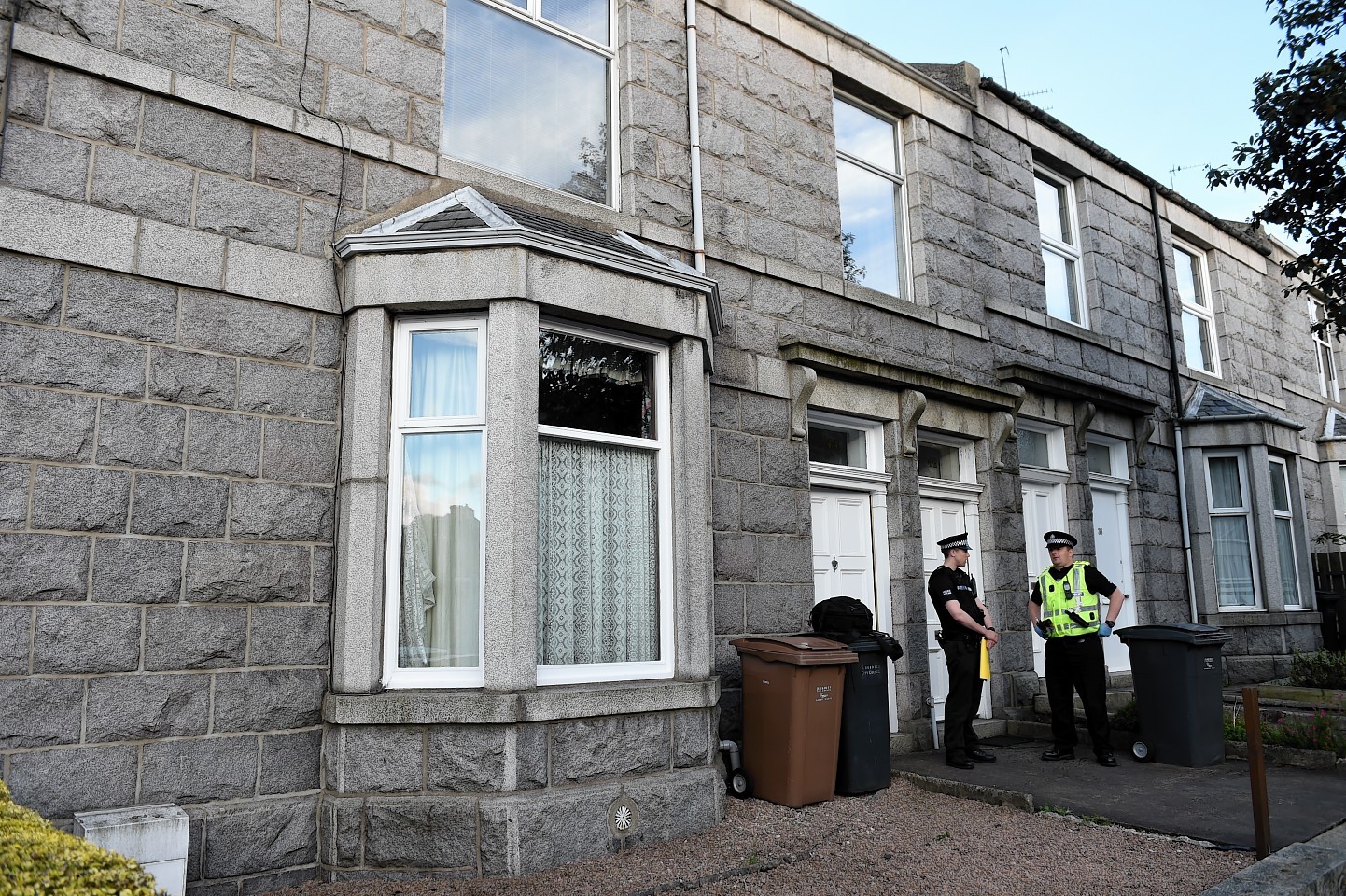Police stand guard outside the property where an elderly woman's body was discovered in Aberdeen. (Picture: Kenny Elrick)