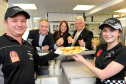 Back L-R: Richard Lochhead MSP, Sarah Medcraf, project director developing young workforce in Moray, and Jim Oag, director Highlands and Islands Services, reaching for the fish and chipsmade by Darren Boothroyd, left, owner of the business, and Elise Boothroyd, right, who works in the shop, at Fochabers Fish Bar after it was presented with an award for Investing in Young People. Picture by Gordon Lennox