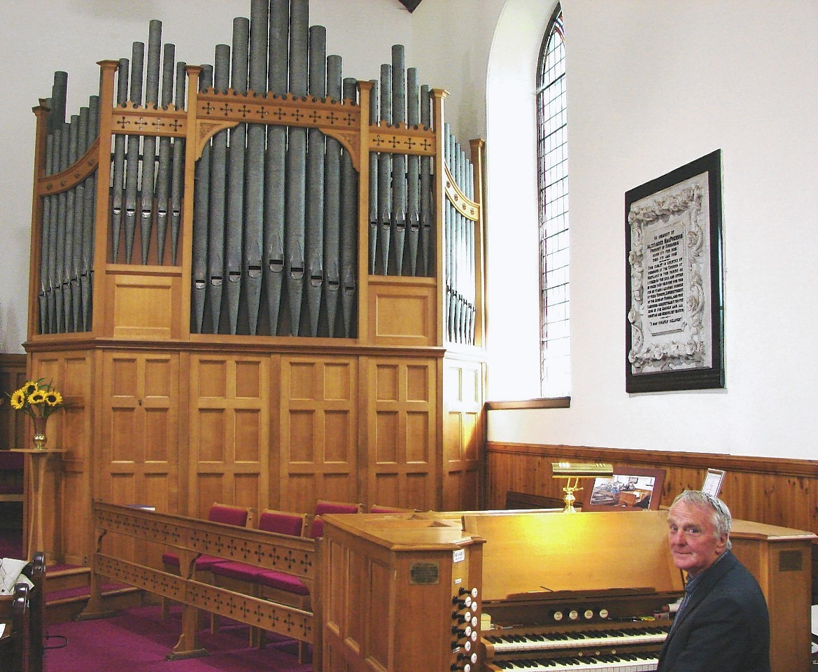 Organist John Crombie with the impressive organ at Kingussie Parish Church