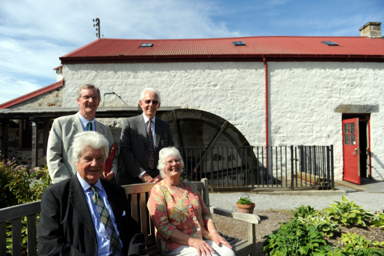 Knockando Woolmill, Aberlour, which won the European Union Prize for Cultural Heritage. Front L-R: Lord Cameron of Lochbroom and Dr Jana Hutt. Back L-R: Tom Duff and Dr Peter Collins, in front of the working water wheel. Picture by Gordon Lennox