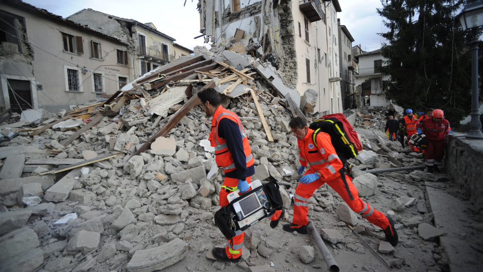 Rescuers search a crumbled building in Arcuata del Tronto, central Italy (AP)