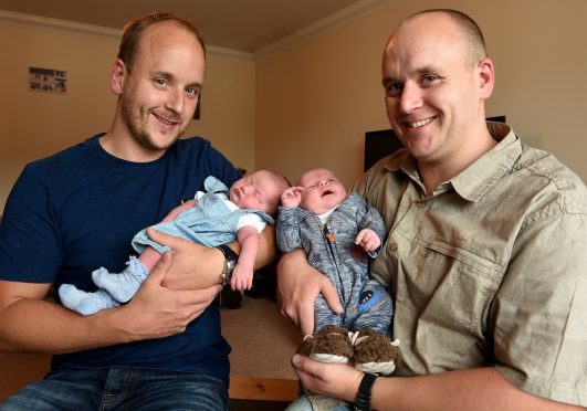 Identical twins Steven and David Bisset with babies Kella and Robbie. Pic by Sandy McCook.