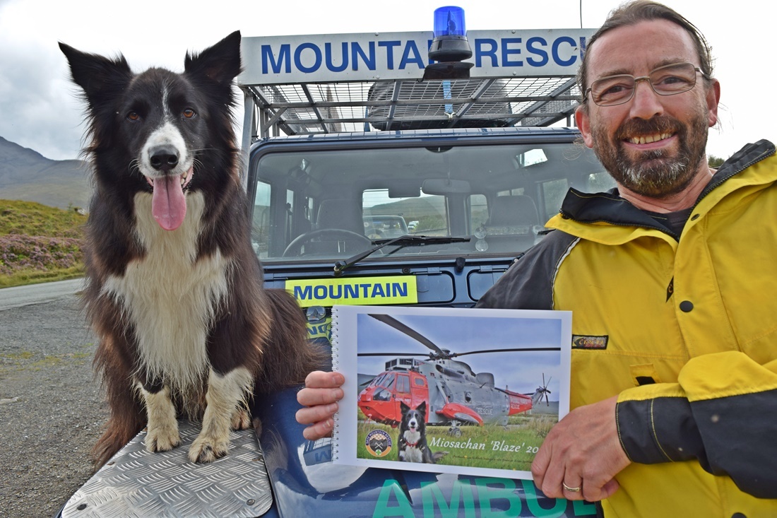 Blaze with his new calendar and Skye Mountain Rescue Team member Stuart Ashton