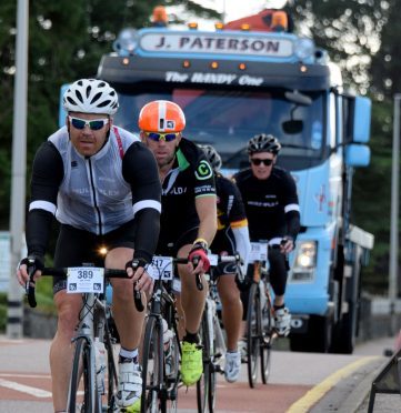 A large truck waits to pass a group of cyclists on the crowded A82 at Fort William