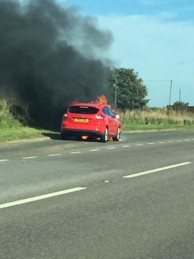 The red Ford Focus on fire at the Toll of Birness