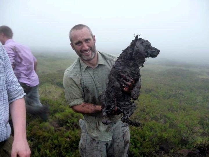 Gamekeeper Jonny Stevenson with Jazz. See Centre Press story CPHOLE; These dramatic pictures show a brave gamekeeper climbing head first into an underground pipe to rescue a dog who went missing on an Angus moor. Cocker spaniel Jazz disappeared while picking up game during a grouse shoot at the Invermark Estate on Tuesday. She was eventually found down a muddy open pipe on the moor. Gamekeepers dug through 6ft of wet peat to retrieve her Jonny Stevenson pushed himself down the pipe to check on the spaniel's condition.