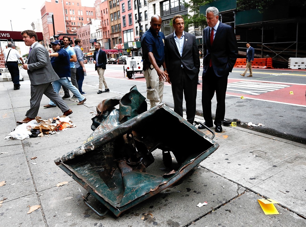 New York Mayor Bill de Blasio, right, and New York Governor Andrew Cuomo, second right, look over a mangled construction toolbox