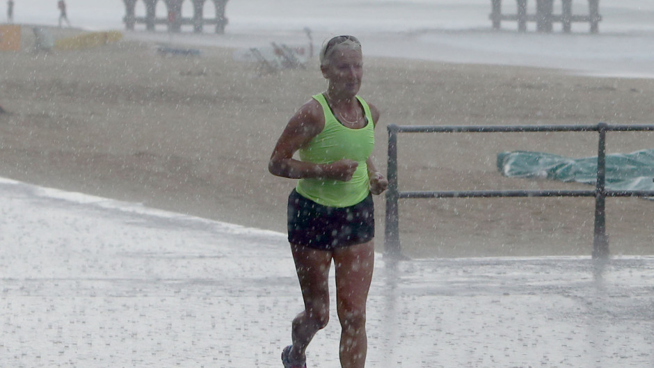 A jogger runs through the rain in Bournemouth.